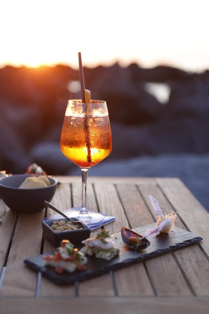 Italian aperitif at the sunset by the sea - The aperitif spread: cured meats, cheeses, bruschetta, and 0 km vegetables